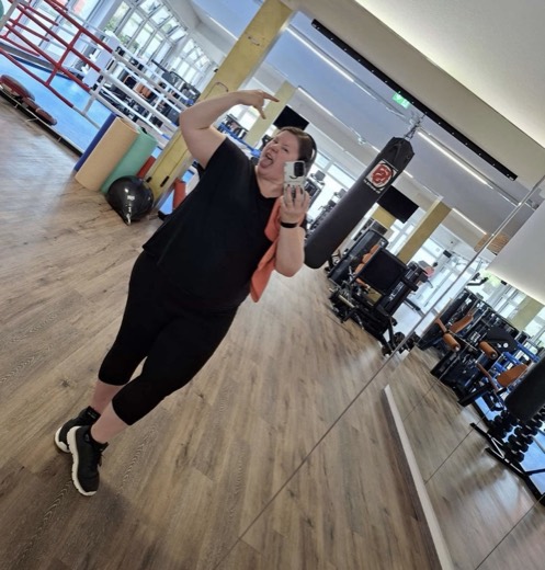 Eine Frau aus der Begleitung, froehlich im Fitnessstudio